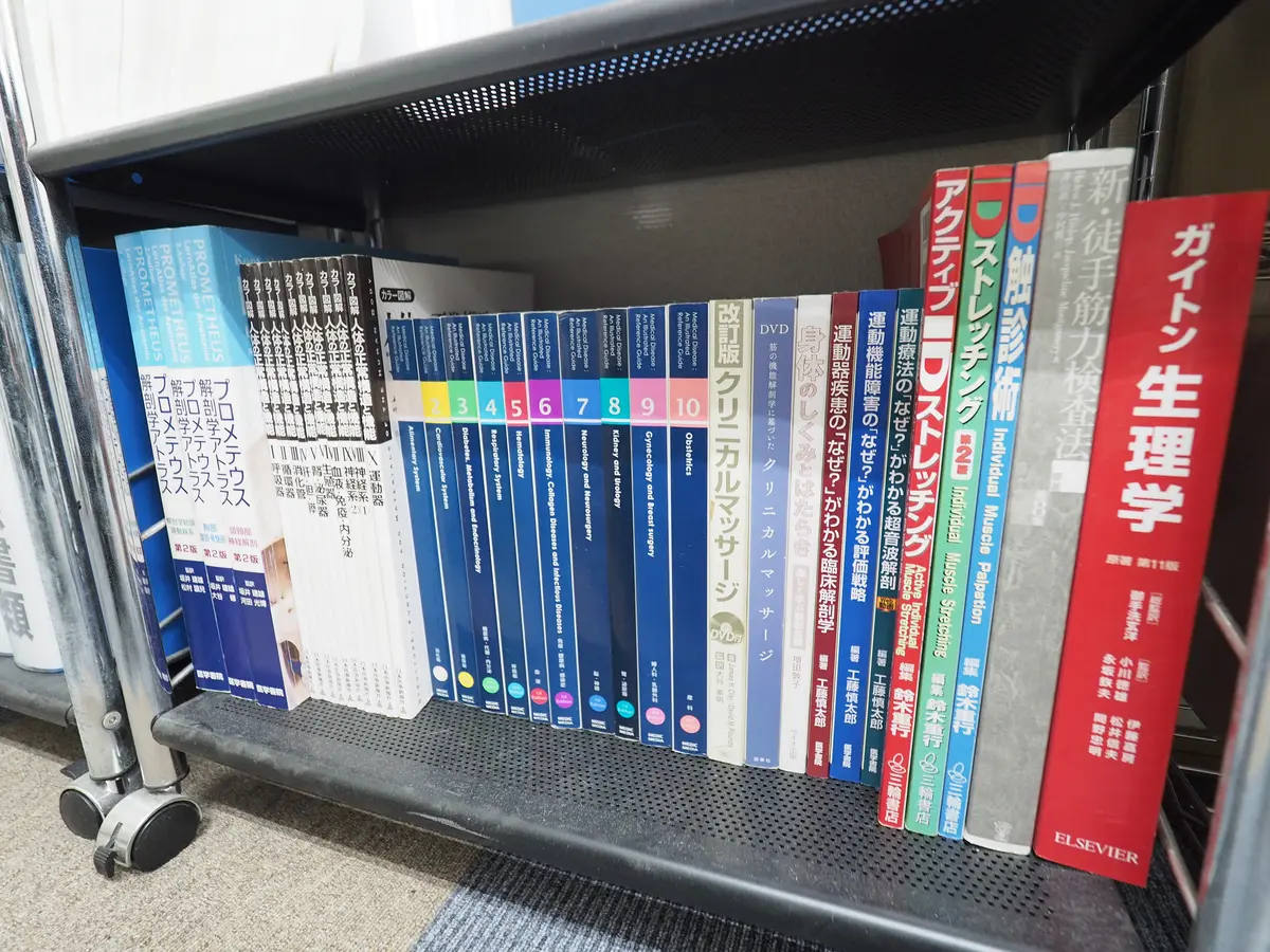 トレーニング指導のために揃えられた解剖学・生理学の専門書棚